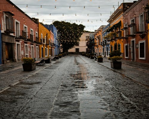 A window view looking out over a rainy street in a Mexican town